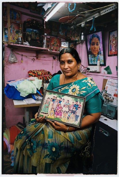Nandini Kantin sostiene una fotografía de su familia en su casa, que también funciona como taller de confección de ropa infantil, en el sector dedicado al negocio textil, en Dharavi.