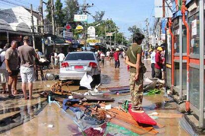 Residentes y turistas del distrito de Patong, en Phuket (Tailandia) deambulan por las calles inundadas por las las olas gigantes o <i>tsunamis</i>.