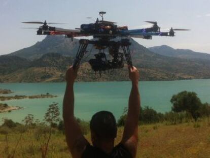 Un t&eacute;cnico suelta el multicopter para rodar el embalse de Zahara de la Sierra.