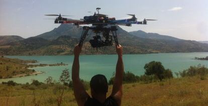 Un t&eacute;cnico suelta el multicopter para rodar el embalse de Zahara de la Sierra.