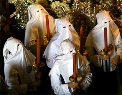 Un grupo de penitentes espera el inicio de la procesión de la hermandad de Los Negritos, en Sevilla.  En la noche del Jueves Santo son seis las grandes procesiones que recorren la ciudad andaluza en la llamada <i>Madrugá</i>: la de la Macarena, la del Silencio, la del Gran Poder, la de los Gitanos, la de la Esperanza de Triana y la de El Calvario, acompañadas por más de 10.000 nazarenos.