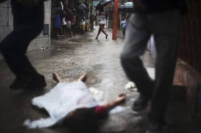 El cuerpo de una persona identificada por la policía como Rodrigo, se encuentra tirado en la calle donde le dispararon en el barrio de Alto do Cabrito en Salvador de Bahía.