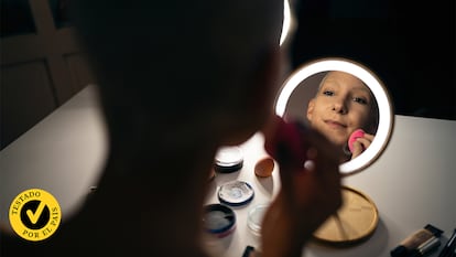 Espejo con iluminación con una persona usándolo.