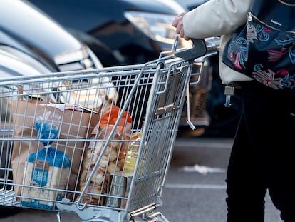 Una mujer sale de un supermercado con un carro de la compra, a 27 de diciembre de 2022, en Mejorada del Campo, Madrid (España).