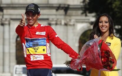 El ganador de la Vuelta Ciclista a España 2012, Alberto Contador, hace el gesto de disparar con los dedos, con el jersey rojo, en el podio de La Cibeles, al término de la última etapa, Cercedilla-Madrid.