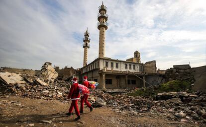 La navidad ha regresado a la comunidad cristiana en Irak en medio del refuerzo de la seguridad, un año después de la victoria sobre las fuerzas del Estado Islámico. En la imagen, dos Papá Noel en su recorrido por las calles de Mosul.