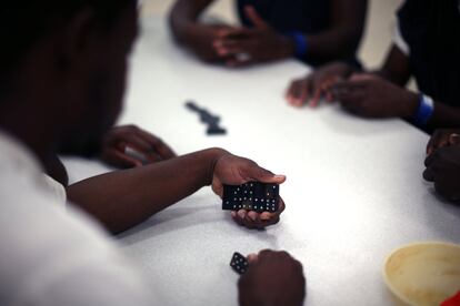 Un hombre juega al dominó con sus compañeros del centro de detención de inmigrantes.