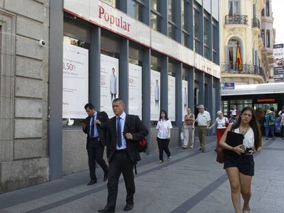 Transeúntes pasan delante de una sucursal del Santader y otra del Banco Popular