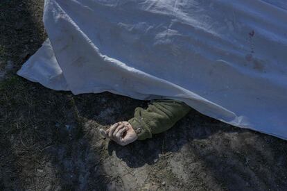 Cuerpo de un soldado ucranio, cubierto por una sábana, tras ser rescatado entre los escombros de un cuartel militar alcanzado por cohetes rusos, en Mikolaiv, este sábado. Decenas de personas han muerto según han explicado este sábado testigos a la agencia de noticias France Presse.