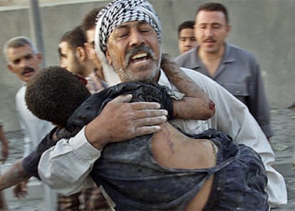 Un hombre lleva en brazos a su hijo herido tras el bombardeo estadounidense de la ciudad iraquí de Faluya.