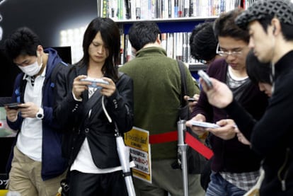 Jugadores con consolas portátiles de Sony en una feria de Tokio.