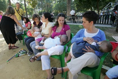 Un grupo de mujeres dan el pecho a sus hijos.