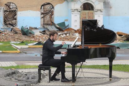 El músico lituano Darius Mazintas toca el piano delante del edificio destruido del Centro Cultural de Irpin, cercano a Kiev