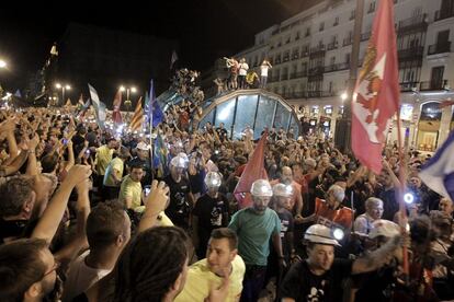 Miles de personas acompañan a los mineros de la "marcha negra", la mayoría vestidos de negro y con las luces de sus cascos encendidas, a su llegada a la Puerta del Sol, en Madrid.