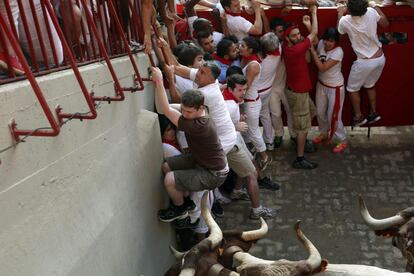 Corredores quedan atrapados a la entrada de la plaza por el callejón tras ser cerradas las puertas de la plaza para evitar la salida de un cabestro malherido tras chocar con un toro en los corrales de la plaza.