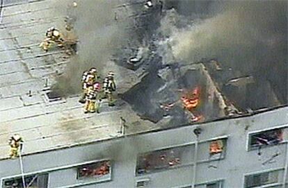 Los bomberos inspeccionan los destrozos provocados por la caída de una avioneta sobre un edificio de apartamentos en Los Angeles.