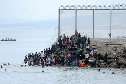 Inmigrantes irregulares en el espigón de la frontera entre Ceuta y Marruecos, este martes.