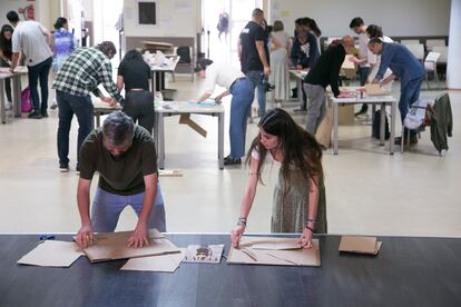 Los ilustradores Luis del Árbol y Sara Luque diseñan con cartón las plantillas de las portadas del libro 'Equipaje de Mano' en el Centro Municipal de Mayores Pérez Galdós, en Madrid.