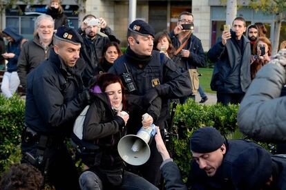 Mossos d'Esquadra arrosseguen una de les manifestants que feia un piquet a la plaça Cerdà de Barcelona.