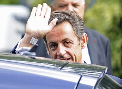 El presidente francés Nicolas Sarkozy saluda al abandonar el hospital.