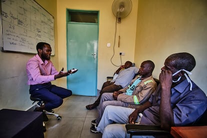 Kumbukani Kaliwo, trabajador social, durante una sesión de grupo con los maridos de las pacientes. No es habitual que los cónyuges acompañen a las mujeres enfermas a sus consultas y tratamientos. Justin Moses, en el centro, dice que compartir su experiencia personal y ver que los otros esposos pasan por lo mismo le ha hecho entender la importancia de permanecer al lado de su pareja.