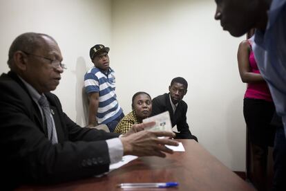 Wisniek Balde "Chiquito" , Michellene Honorec, y Nelson Balde observan ilusionados cómo sus compañeros haitianos recogen el visado en el consulado de Brasil