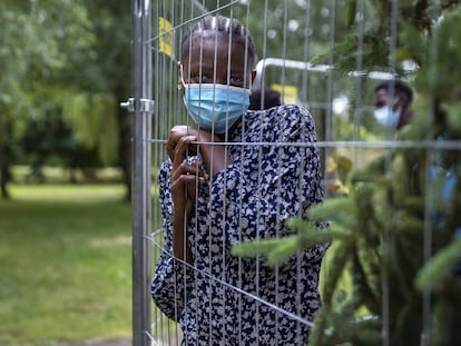 Una migrante de Nigeria, mira a través de una valla en el campo de refugiados en la aldea de Verebiejai, Lituania.