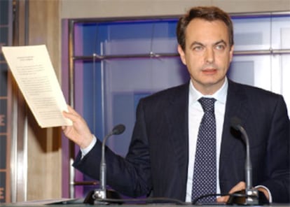 Zapatero muestra una copia del pacto anti-ETA durante su intervención ante los medios en la sede del partido.