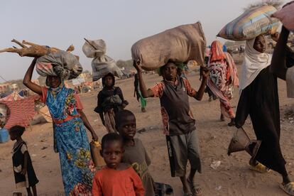 Un grupo de desplazados de la guerra en Sudán, procedentes de Darfur, se dirige a sus refugios el 24 de abril de 2024 en Adre, Chad.