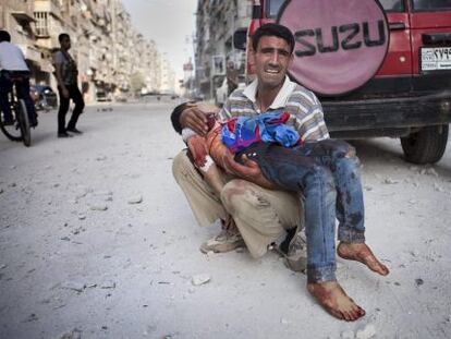Un padre sirio llora con su hijo muerto en brazos en frente del hospital de Dar al Shifa, en Alepo.