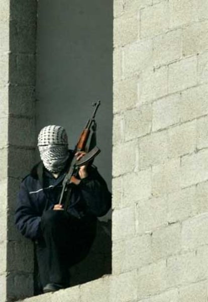 Un policía palestino enmascarado custodia el Parlamento palestino en Gaza.