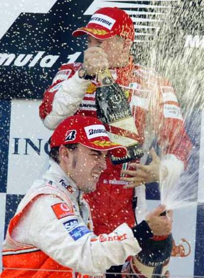 Alonso celebra con champán su segundo puesto con el ganador Raikkonen.