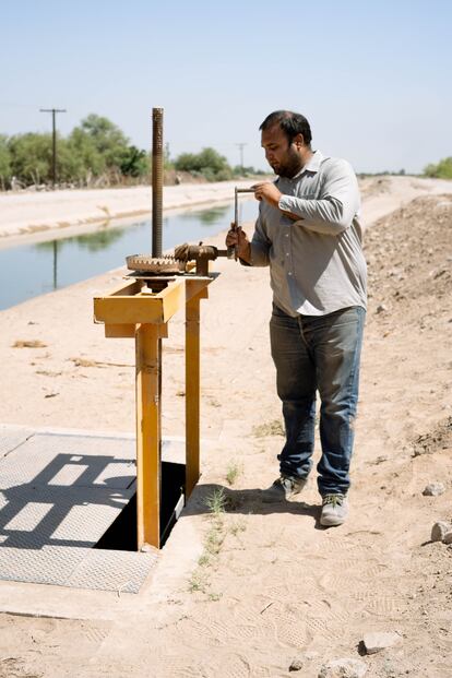 Un trabajador del Sonoran Institute abre la compuerta para que el agua llegue al sitio de restauración ambiental El Chausse, donde la ONG ha reforestado con mezquites, sauces y álamos con el objetivo de recrear parte del ecosistema que existía antes.