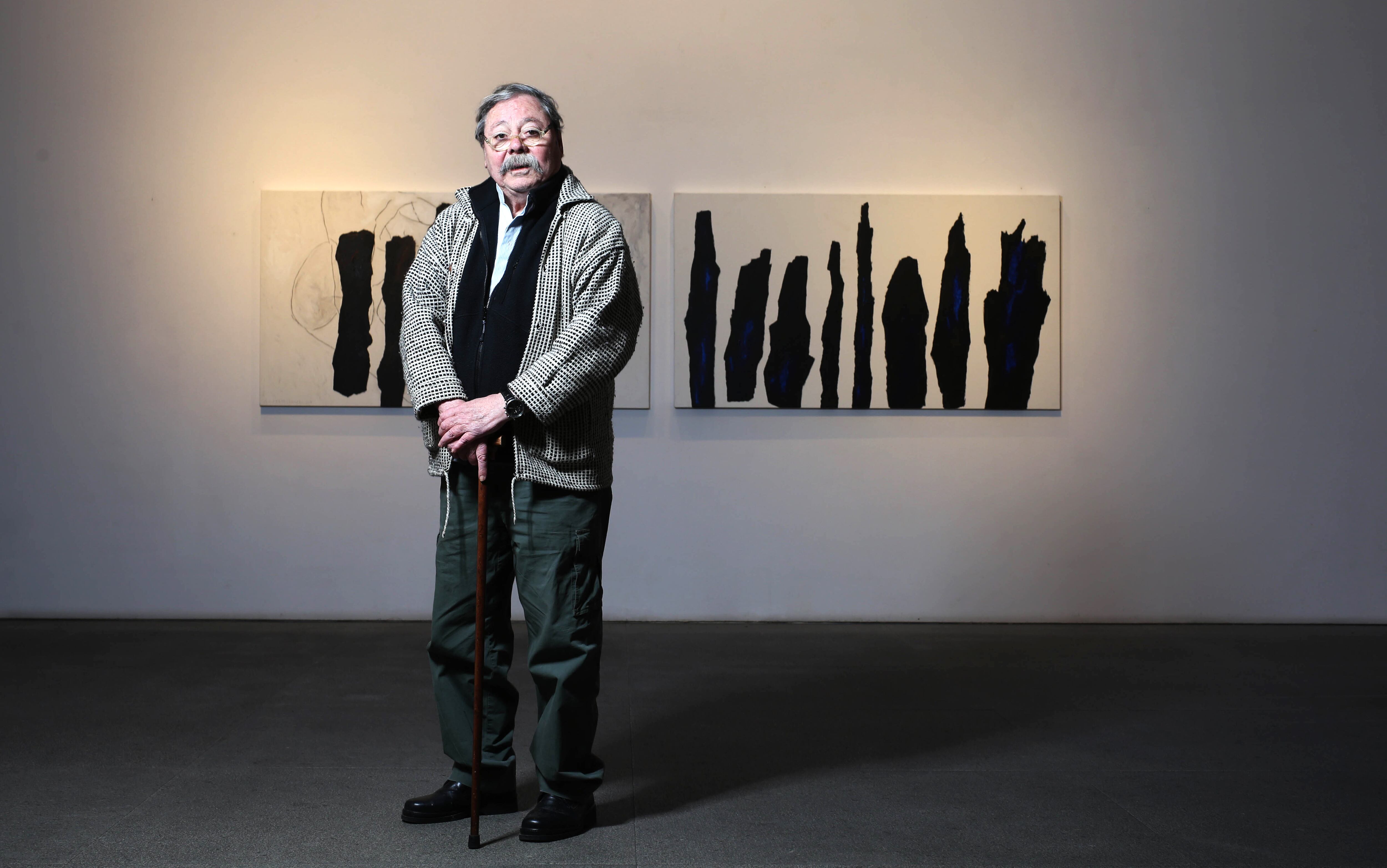 Alberto Corazón, junto a sus obras '¿Qué bosque no ha tenido un fugitivo?' (izquierda) y 'Bosque azul', en su muestra 'Despojarse', en 2017.