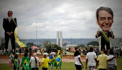 Seguidores del presidente de Brasil, Jair Bolsonaro, caminan frente a un muñeco gigante con su figura en Brasilia (Brasil).