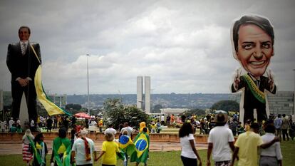 Seguidores do presidente Jair Bolsonaro caminham na frente de um boneco gigante com sua figura em Brasília.