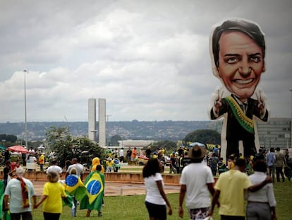 Seguidores del presidente de Brasil, Jair Bolsonaro, caminan frente a un muñeco gigante con su figura en Brasilia (Brasil).