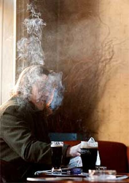 Una fumadora, delante de su pinta de cerveza en Dublín.