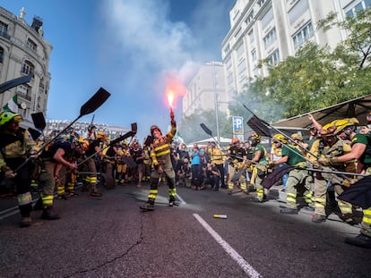 Bomberos y brigadas forestales simulan que apagan un fuego con sus palas mientras se manifiestan, este sábado en Madrid.