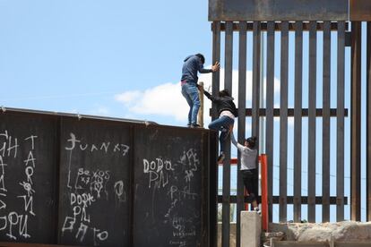 Un grupo de personas tratan de saltar el muro para entrar a territorio estadounidense, desde el puente negro, en la línea fronteriza de Ciudad Juárez, en el estado de Chihuahua (México). 