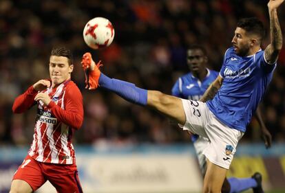 El defensa del Lleida, Marc Trilles, a la derecha, despeja el balón ante el delantero francés del Atlético de Madrid, Kevin Gameiro, a la izquierda, durante el partido de ida de los octavos de final de la Copa del Rey.