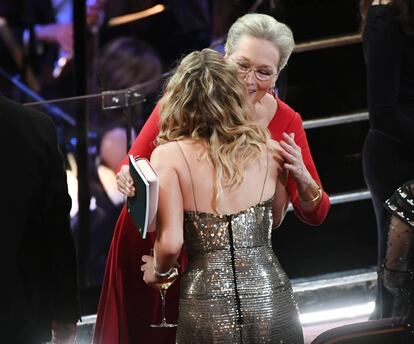 Por fin llega a uno de sus objetivos: saludar a Meryl Streep, que no lleva una copa de vino y sí un bolso y un cuaderno.