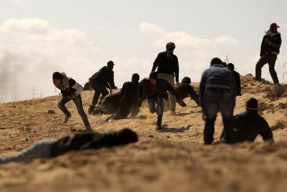 Un grupo de rebeldes busca refugio del fuego de un tanque de las fuerzas de Gadafi a las afueras de Ajdabiya.