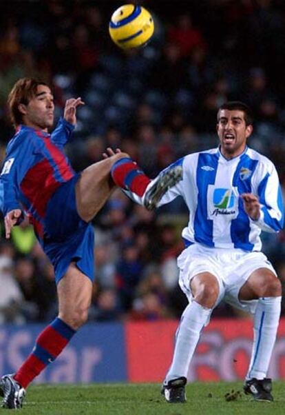 El portugués del Barca Deco se lleva la pelota ante la oposición de Juanito.