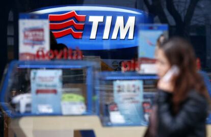 Una mujer habla por su tel&eacute;fono mientras pasa por una tienda de Telecom Italia en Roma.