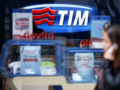 Una mujer habla por su tel&eacute;fono mientras pasa por una tienda de Telecom Italia en Roma.