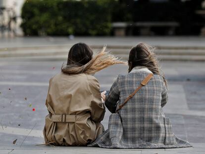 Dos jóvenes, este mediodía, en la plaza de la Virgen de Valencia.