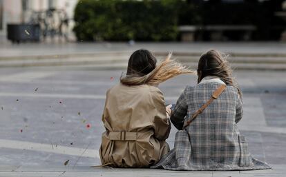 Dos jóvenes, este mediodía, en la plaza de la Virgen de Valencia.