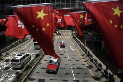 Banderas nacionales de Hong Kong y China ondean en la proximidades de un centro comercial para conmemorar el 20 aniversario de la entrega a China del territorio colonia del Reino Unido.