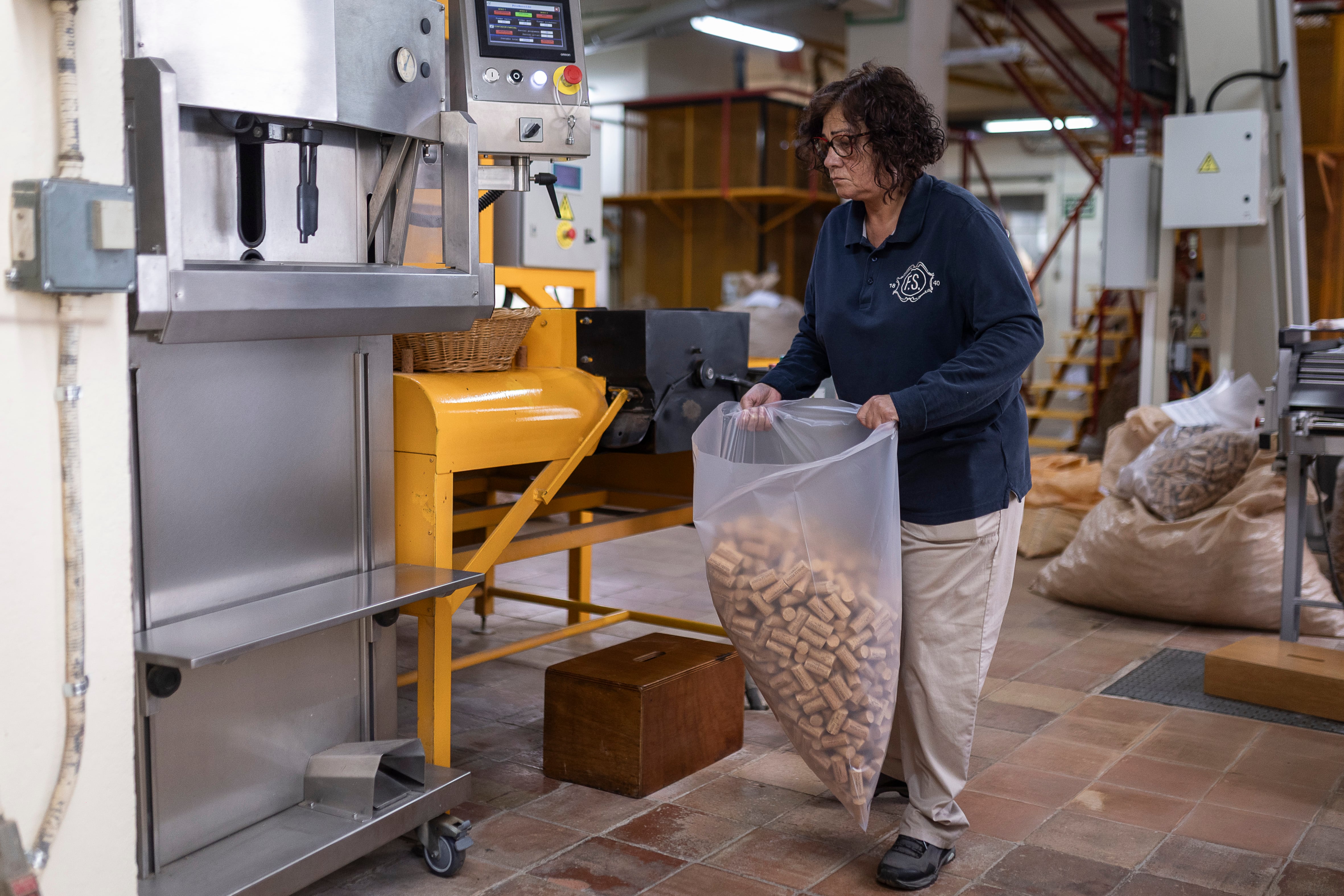 En la imagen, Estrella Morillas empaqueta los tapones una vez finalizados en la fábrica.

